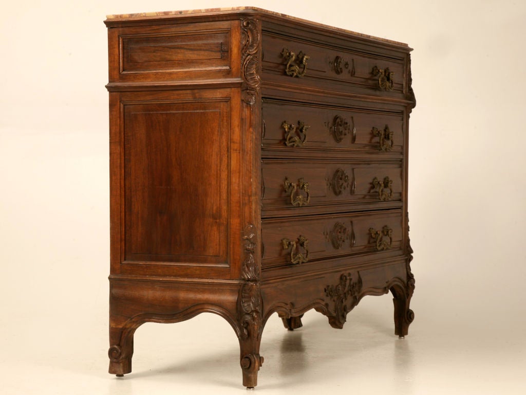 Nicely carved Antique French walnut commode with intricate details, and a marble top. The four drawers glide and function as new.