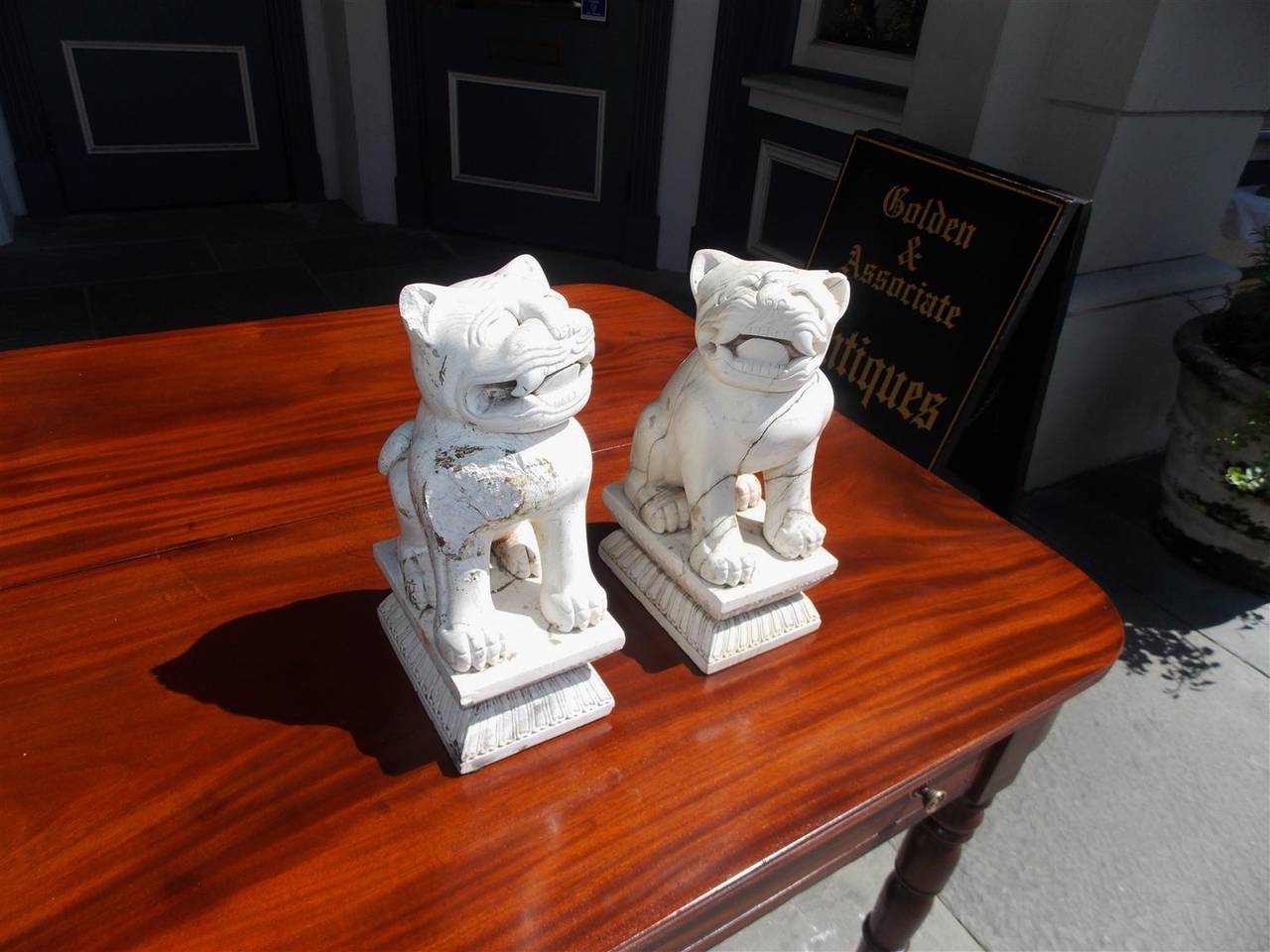 Pair of Chinese hand carved stone Foo dogs resting on rectangular decorative carved plinths. 20th Century