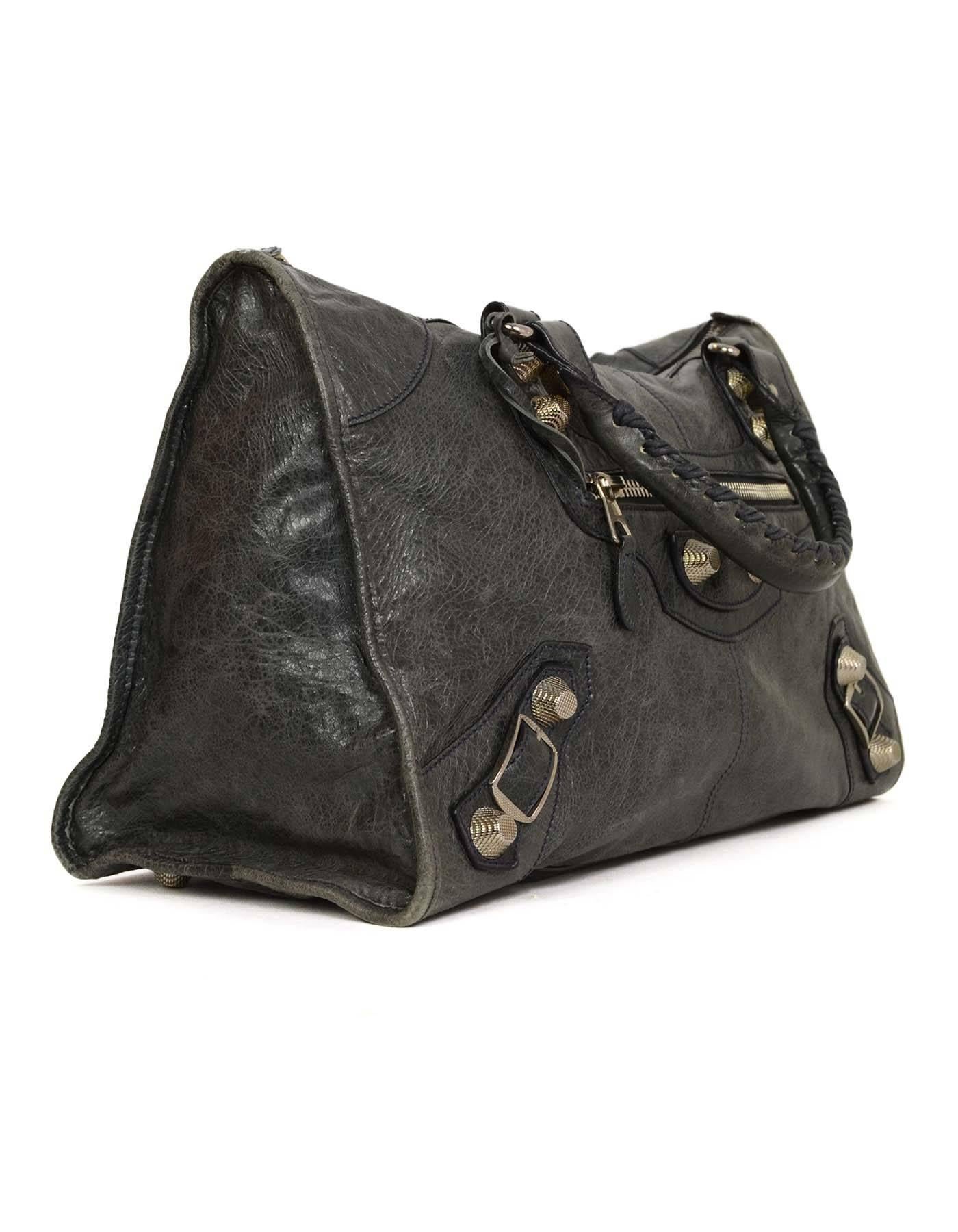 Balenciaga Charcoal Grey Distressed Leather Work Bag
Features giant silvertone hardware

-Made In: Italy
-Color: Charcoal grey
-Hardware: Silvertone
-Materials: Leather, metal
-Lining: Black textile
-Closure/Opening: Zip top
-Exterior