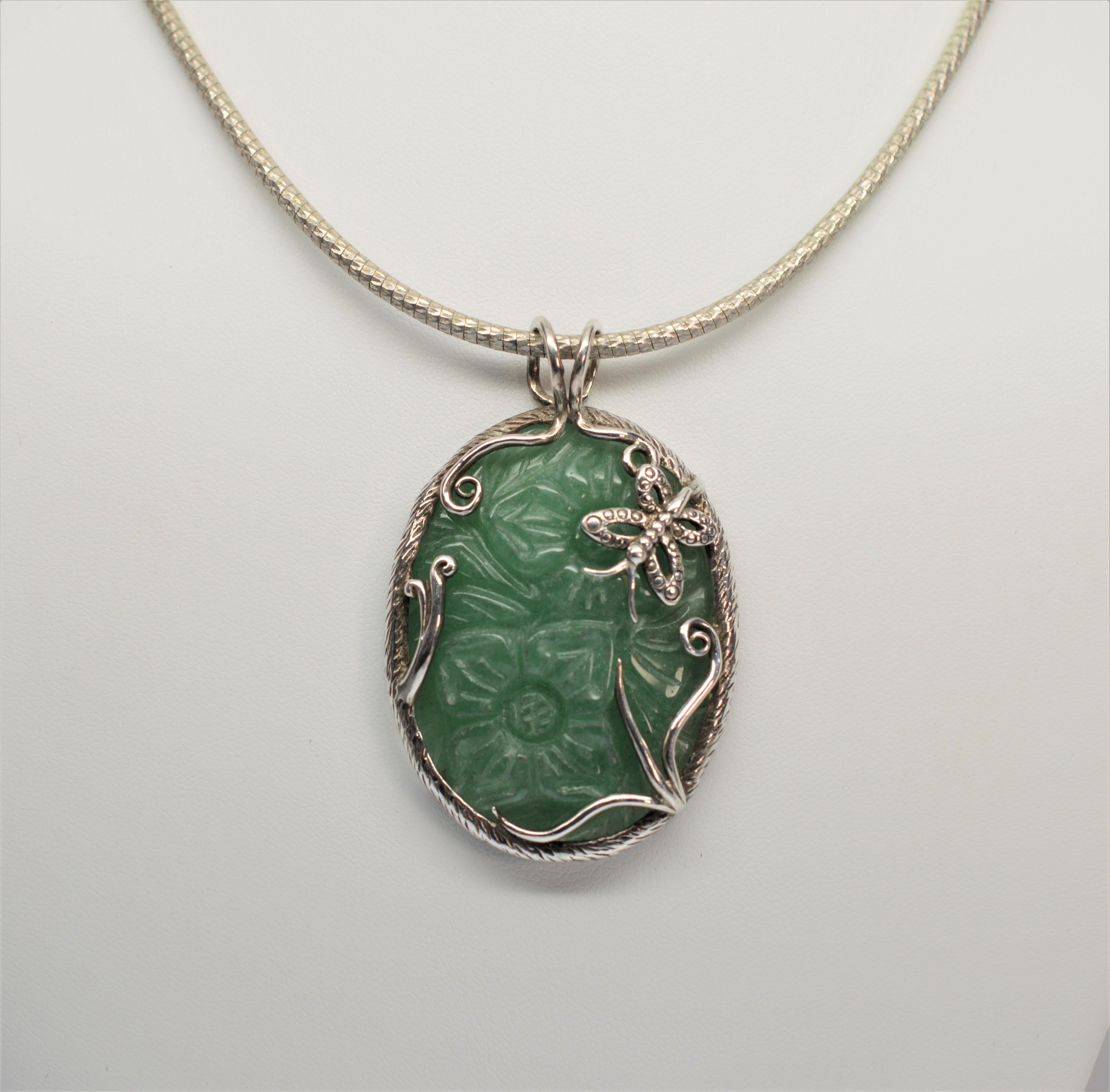 Exquisite Jade Stone with hand-carved floral design mounted in crafted Sterling Silver frame with butterfly and vine design.  Accompanied by a 16 inch Sterling Silver Rope Chain that compliments the piece, but is removable . The stunning artisan