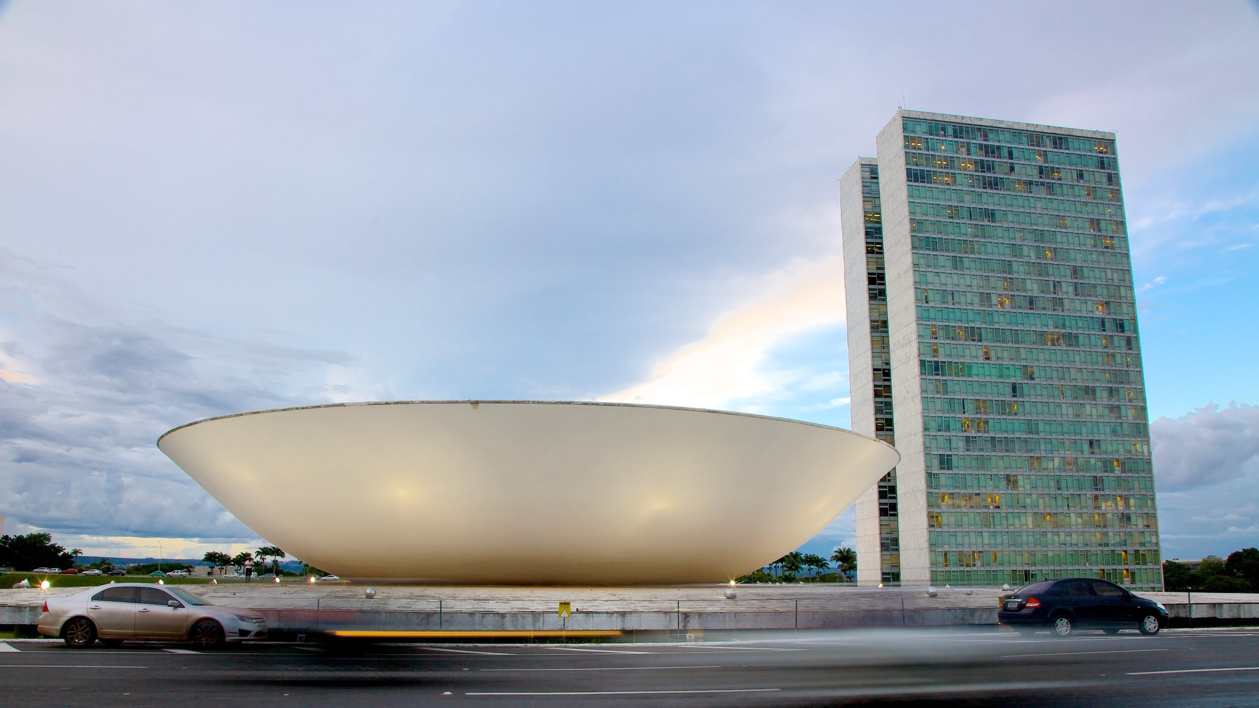 Congresso Nacional do Brasil que inclui uma cidade, arquitetura moderna e cenas de rua