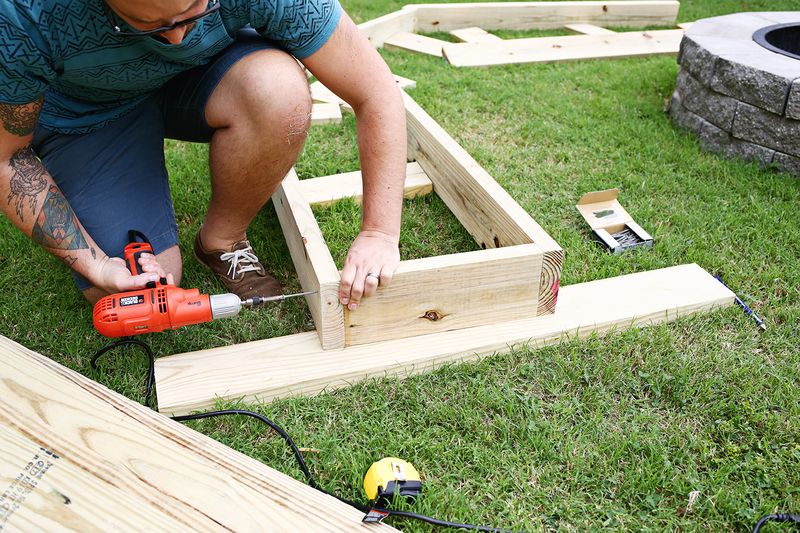 a man drilling into the bottom of the bench