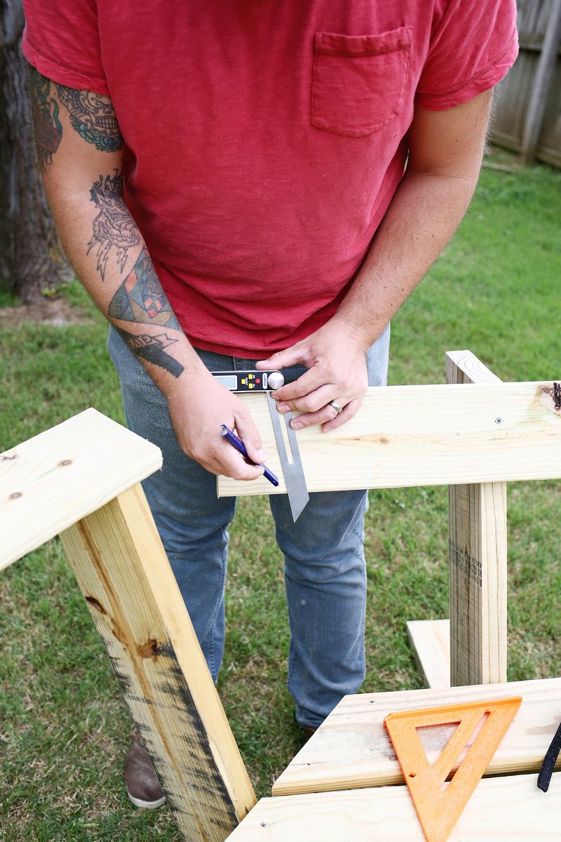 a man drawing a straight edge onto a piece of wood