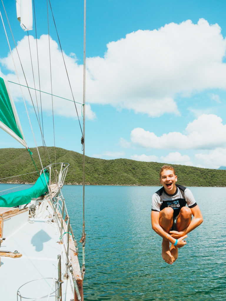 Kid jumping off sailboat in Tayrona National Park, Colombia