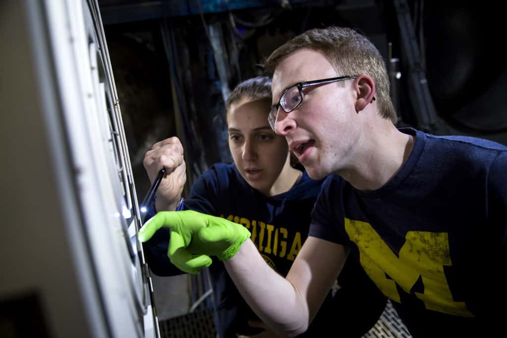 students checking on X3 thruster