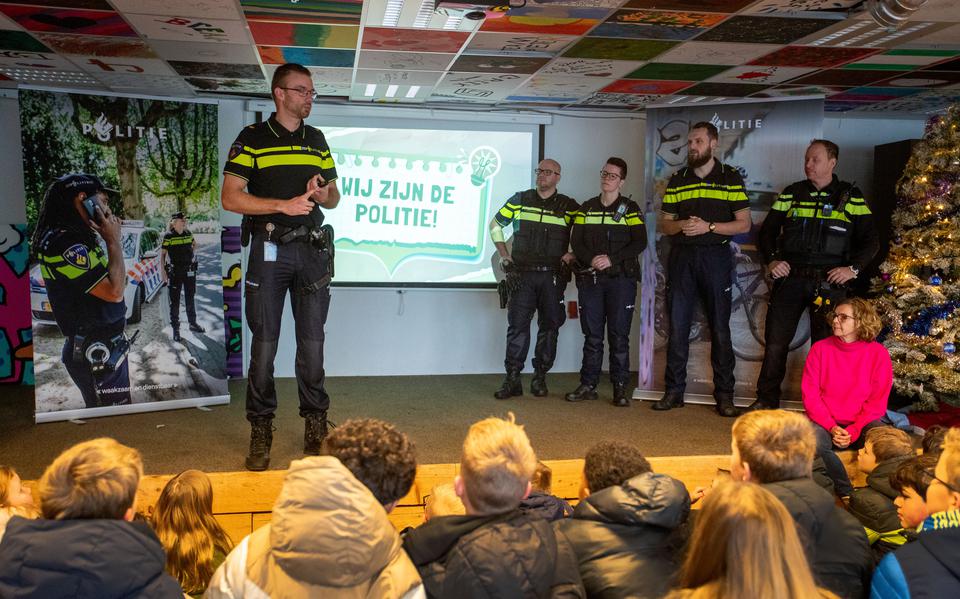 Wijkagent Roy Meier en zijn collega's lichten de basisschoolleerlingen voor over vuurwerk en online veiligheid.