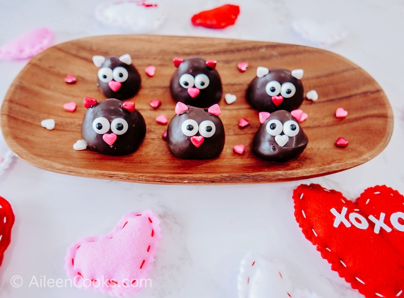 6 chocolate covered strawberry love birds on a wooden tray.