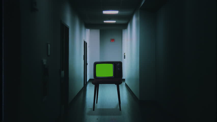 Green Screen TV Dark Corridor Old VHS Television Effect Eerie Scene Zoom In. Walking through an eerie dark corridor flickering lights with a green screen TV, retro VHS effect. Tracking shot