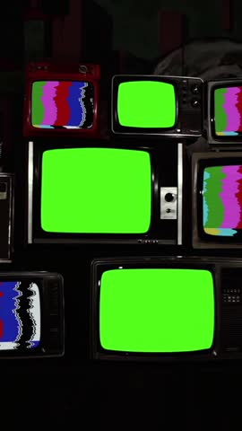 Three Green Screen TVs Surrounded by Stacked Old Televisions from the 80s and 90s, Ending with Zoom-In - Vertical 4K Video