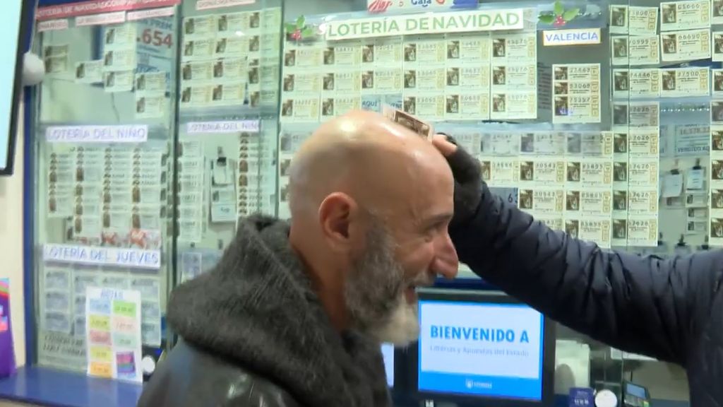 Un cliente frota un décimo de lotería en la cabeza de un calvo