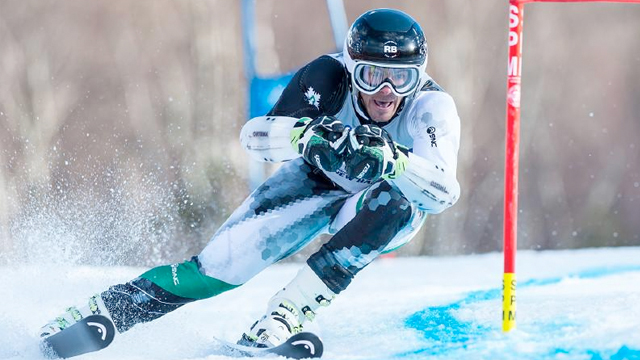 A Dartmouth downhill racer carves a turn around a gate during a race