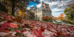 Clayton University Center in the fall surrounded by fallen leaves