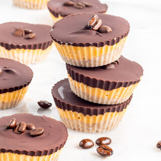 Stacked chocolate candy cups with coffee beans on the table.