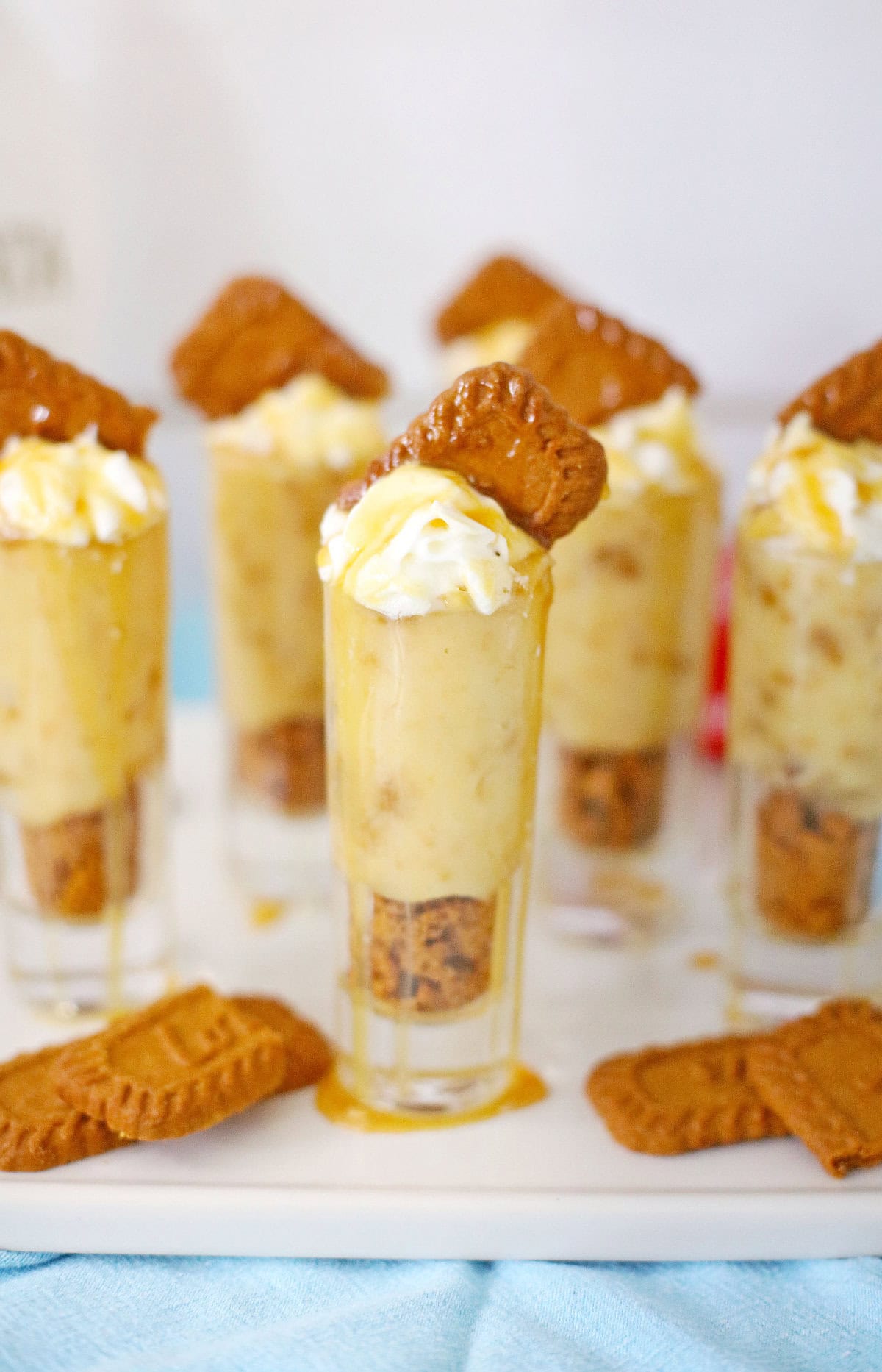 Cookie pudding shots on a tray with more Biscoff cookies.