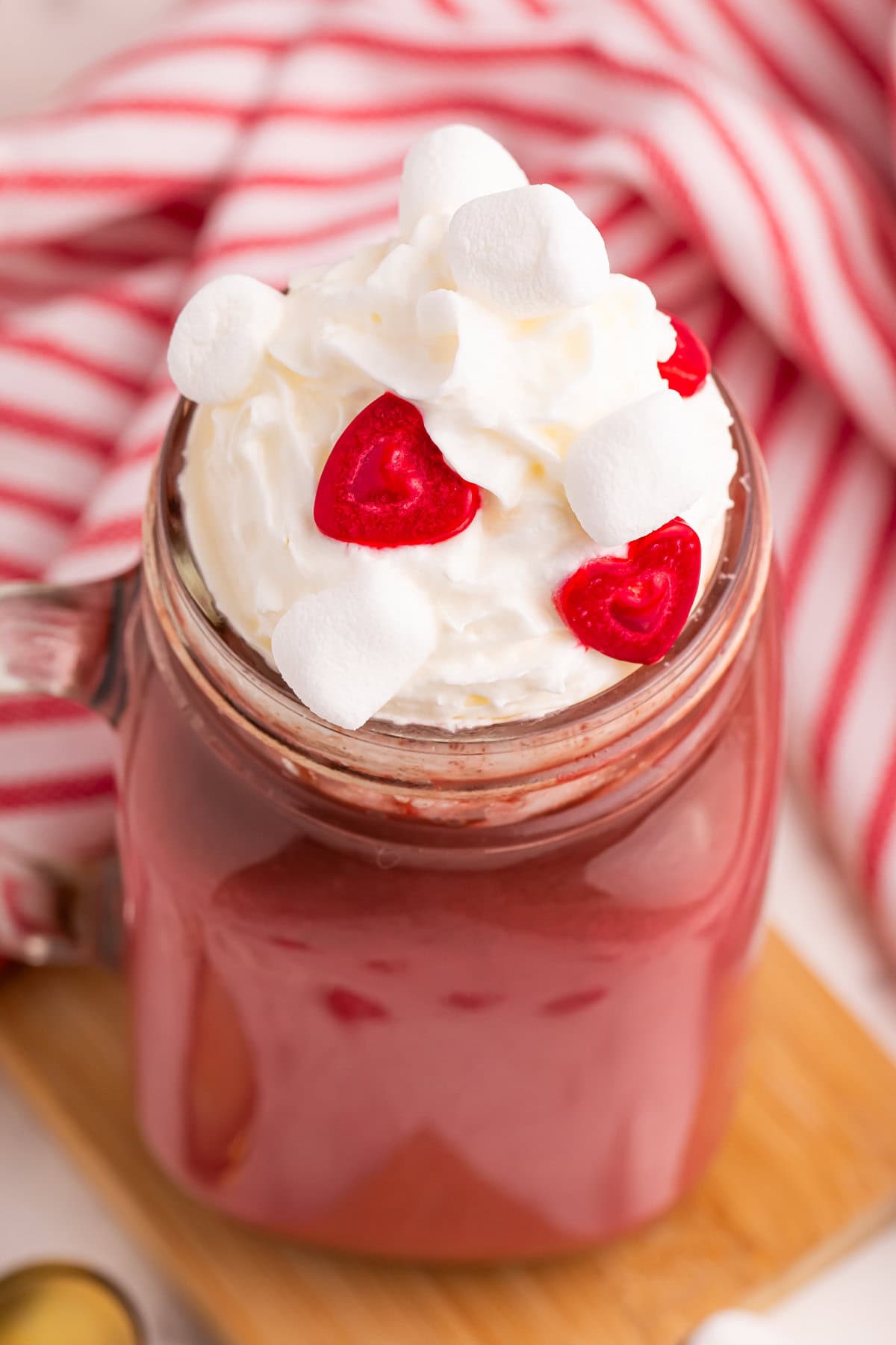 Red velvet hot cocoa topped with whipped cream and red heart sprinkles.