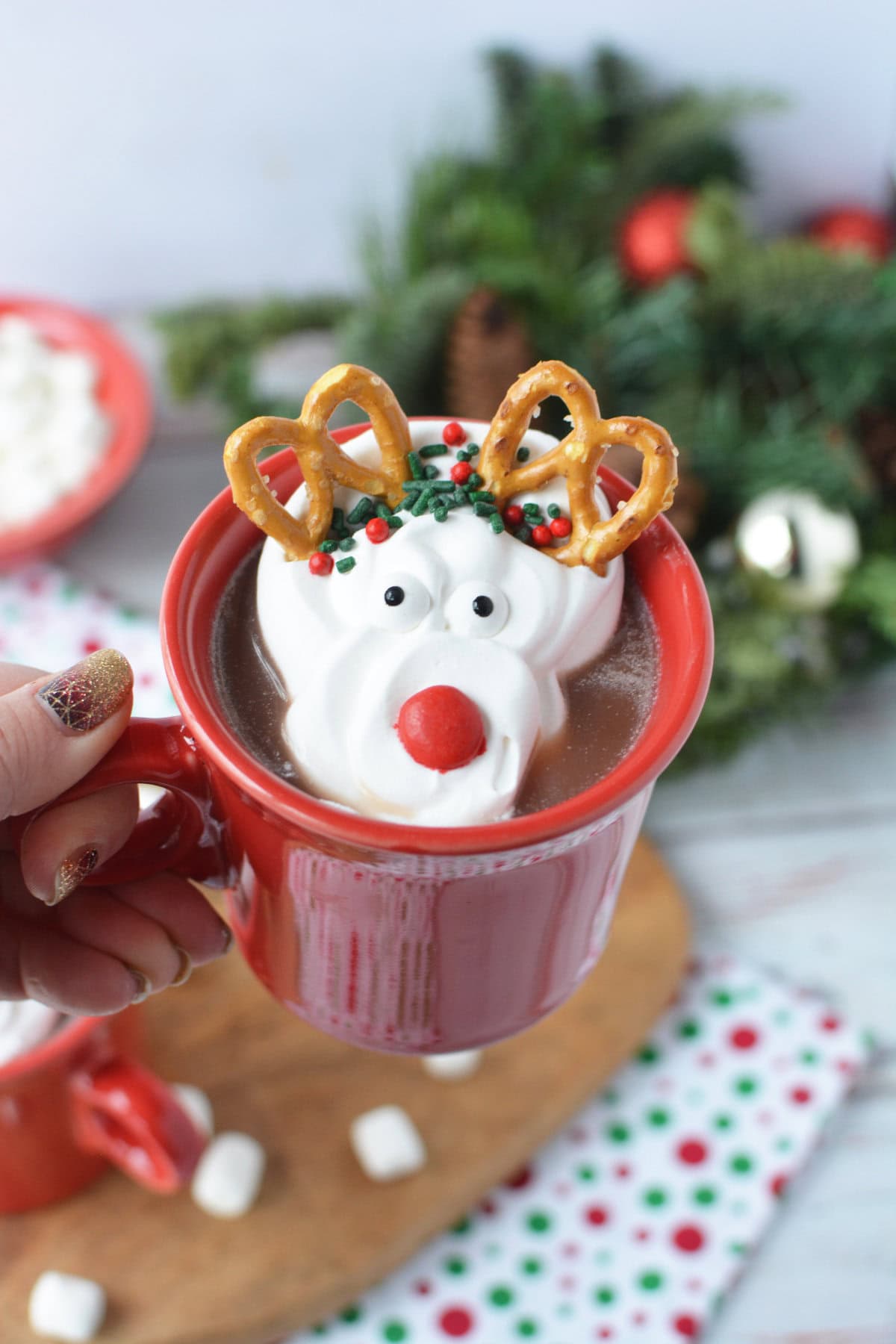 Holding a mug of hot chocolate with a whipped cream reindeer on top