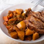 venison roast in a bowl with spoon