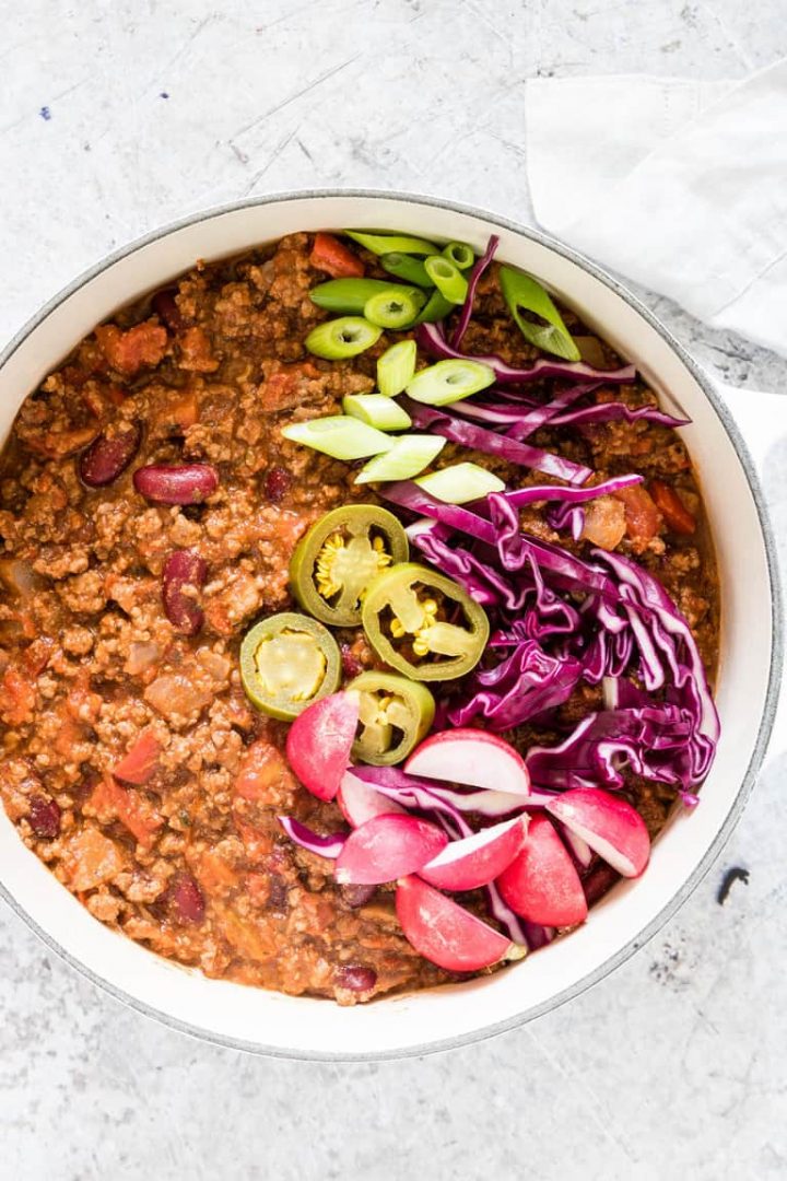 bowl of venison chili with garnishes on top