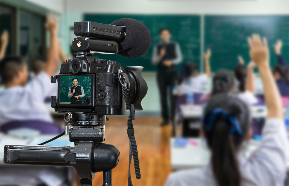 Teacher in a classroom using video and a microphone