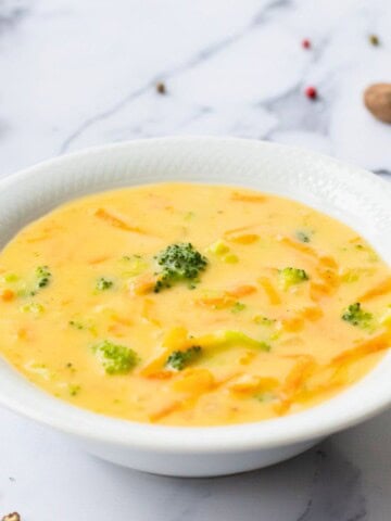 Copycat Panera Broccoli Cheddar Soup dished out in white bowl.