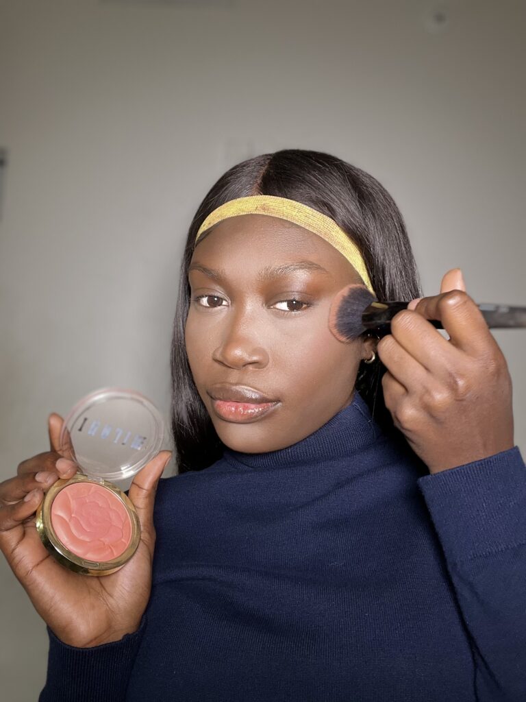 black woman using milani pink rose blush