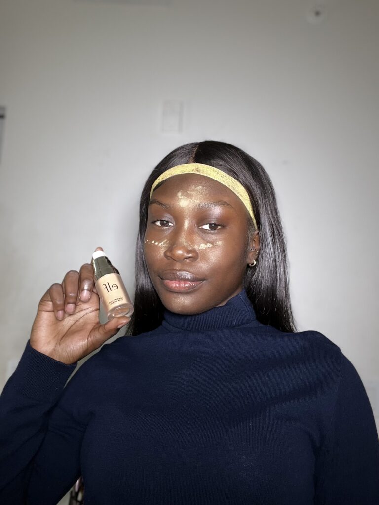 dark skin woman wearing turtleneck and using elf primer