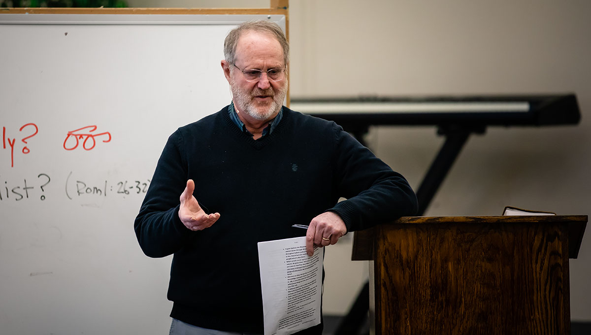 Man holding paper talking at a podium