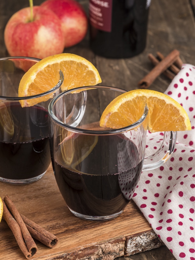 Two glasses of mulled wine on a wooden board.