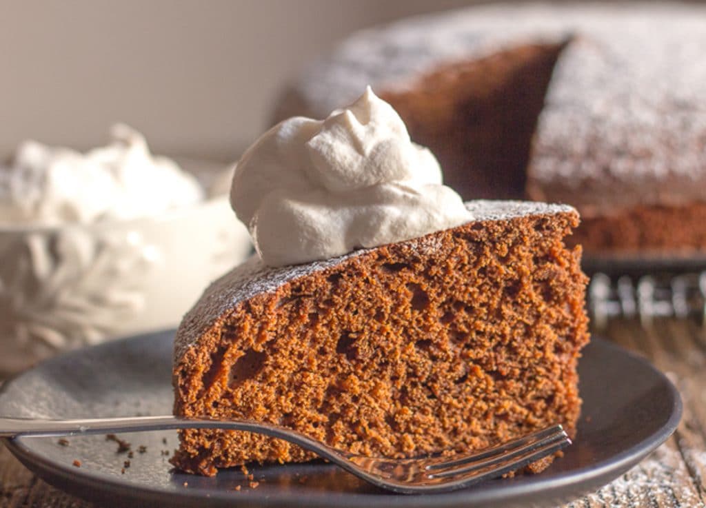 Slice of gingerbread cake on a black plate.