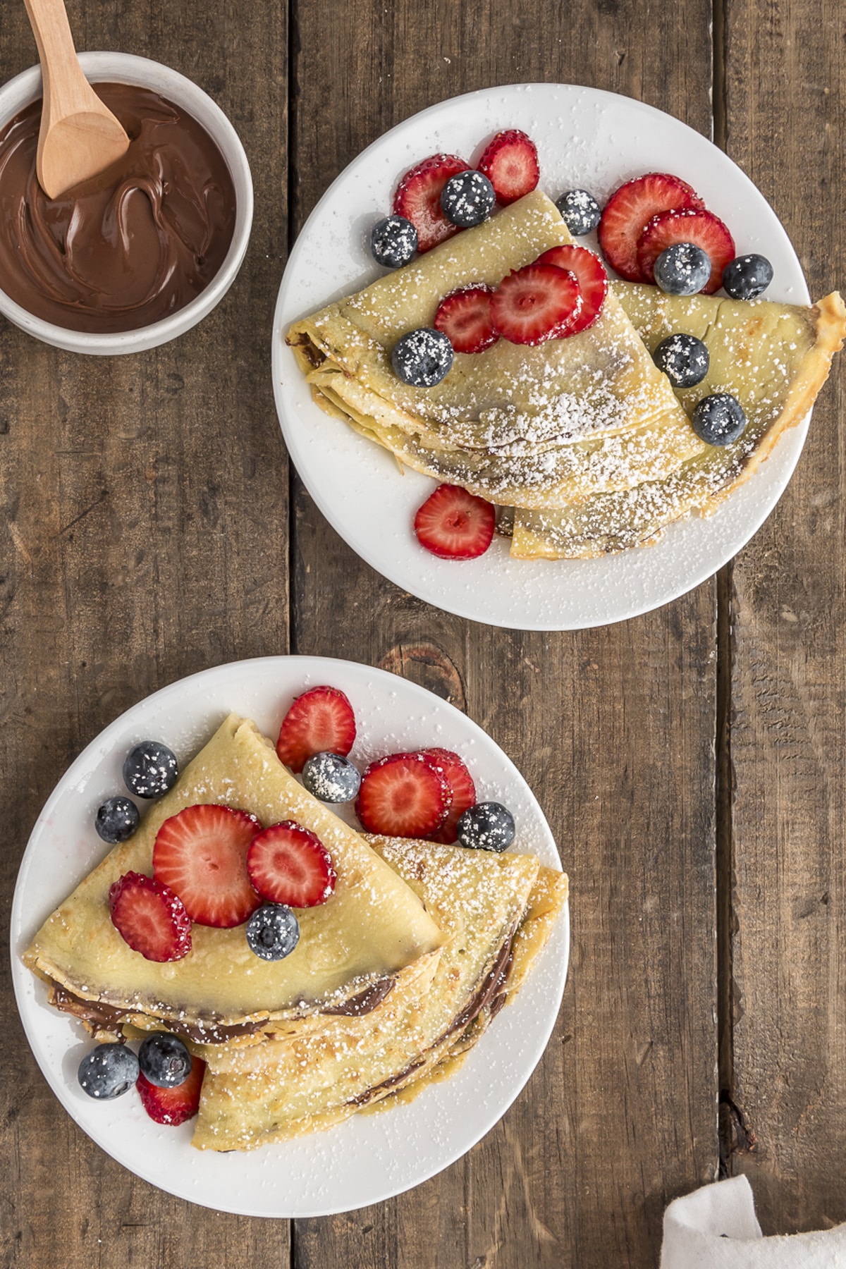 Crepes on two white plates.