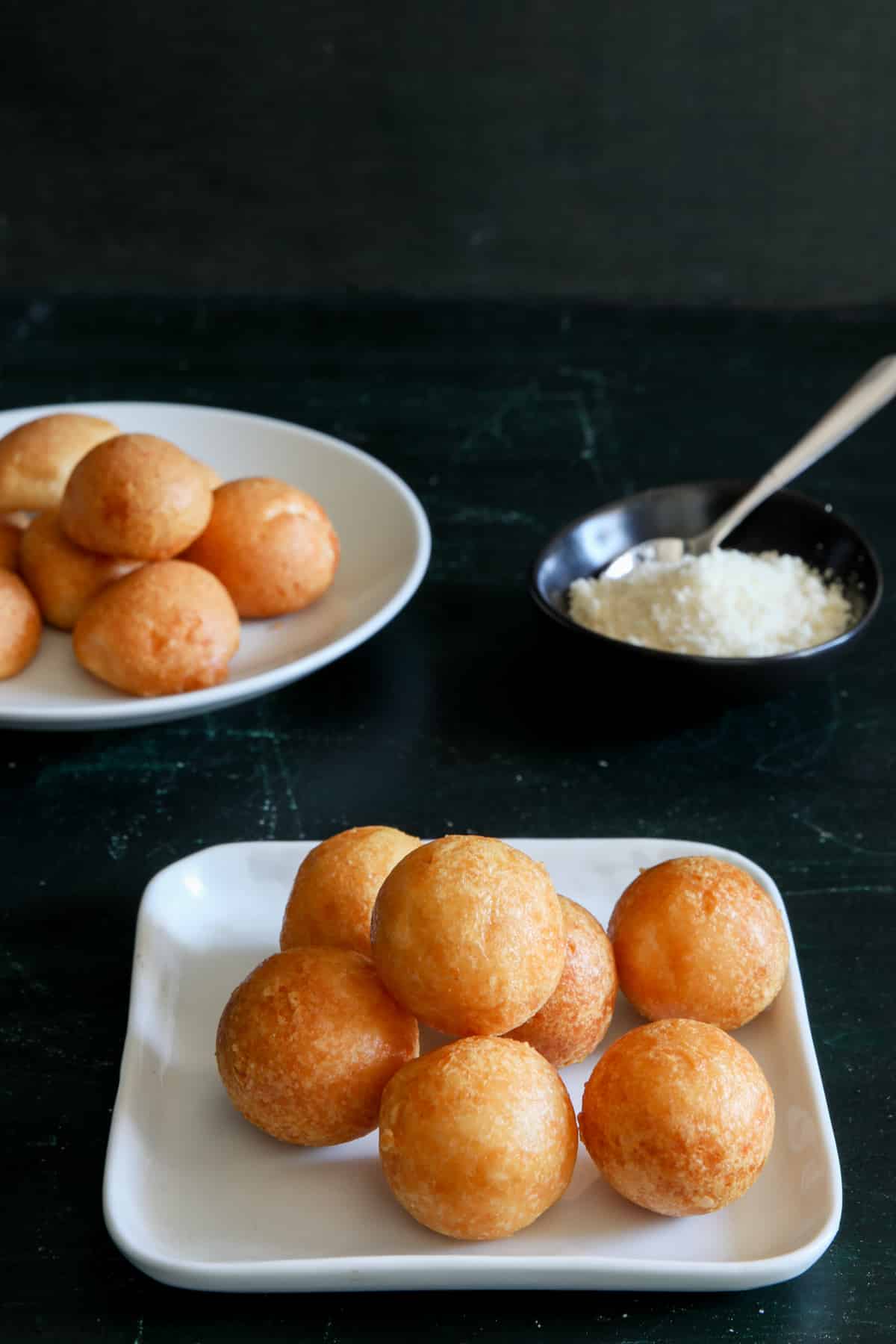 Cheese balls on a white square plate and a round plate.