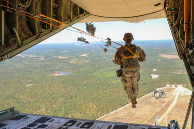 Stepping out into open air, Headquarters and Headquarters Company, U.S. Army Civil Affairs and Psychological Operations Command (Airborne) Soldiers exit a U.S. Marine KC-130 aircraft during a static line jump over Sicily Drop Zone, Ft. Bragg,...