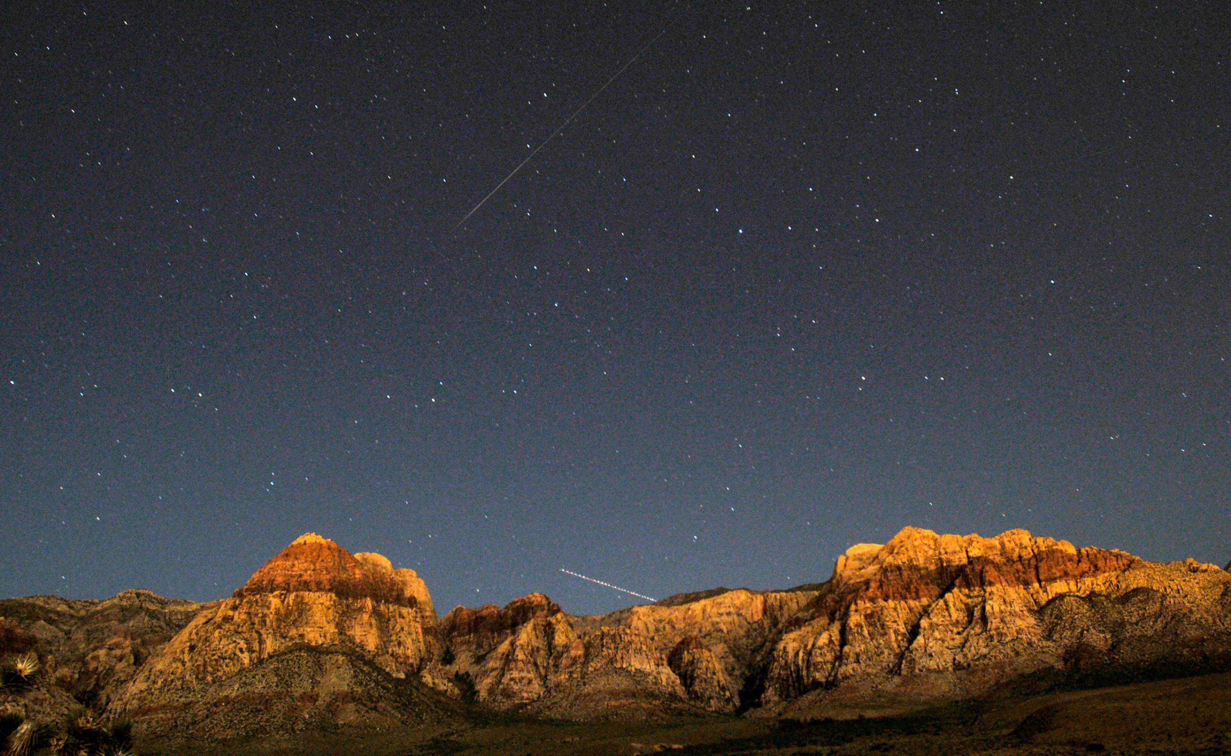 A Perseid meteor (top) and the trail of an jet airplane converge over the cliff walls of Red Rock Canyon outside of Las Vegas on Aug. 11, 2009.