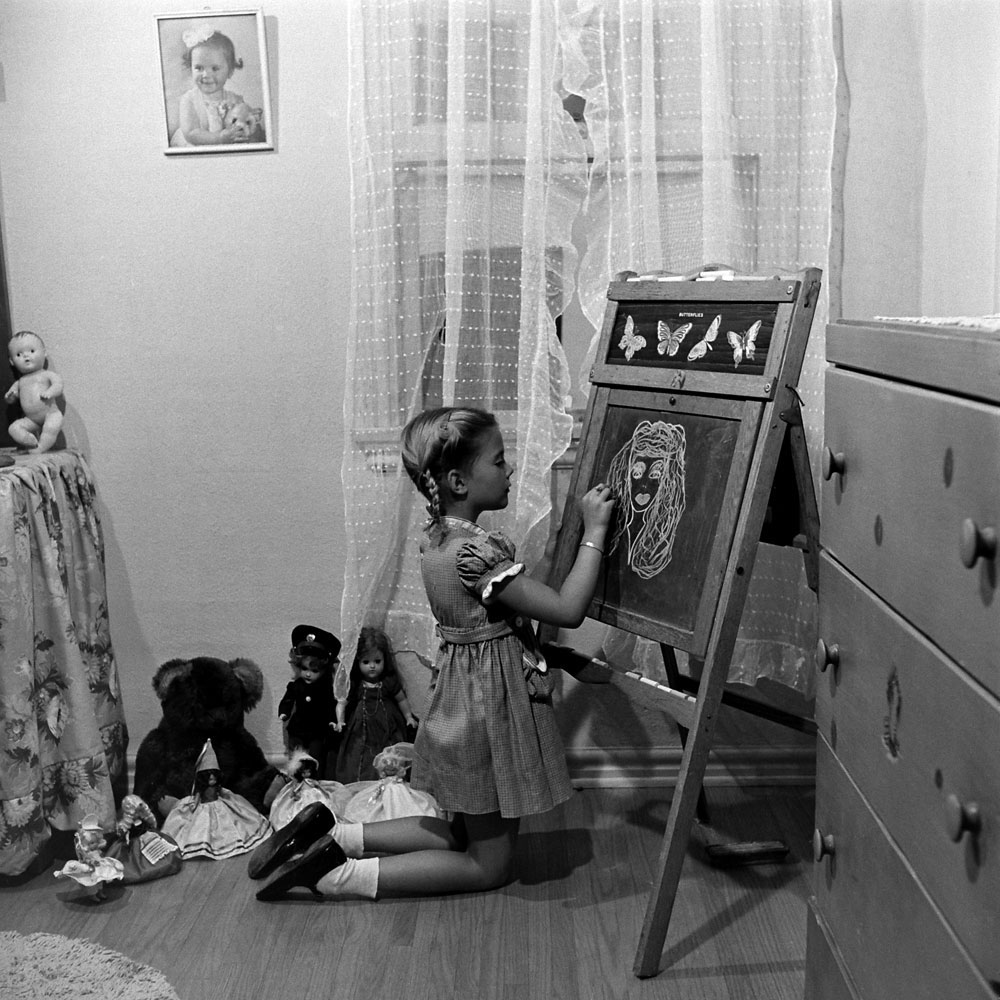 Natasha Wood drawing a girl's face on her blackboard.