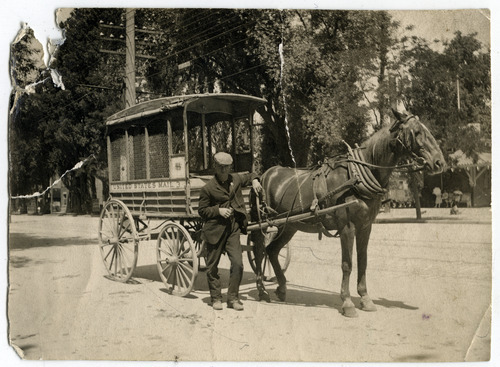 Tribune file photo

A man stands with a U.S. Mail wagon in this undated photo.