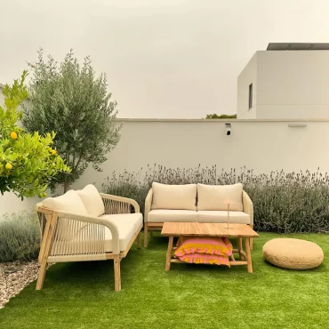 salon de jardin en bois et rotin en beige pelouse verte pouf