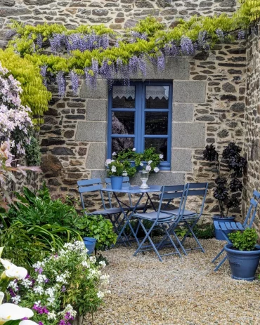 sol en gravier coin repas table et chaises en bleu plantes grimpantes