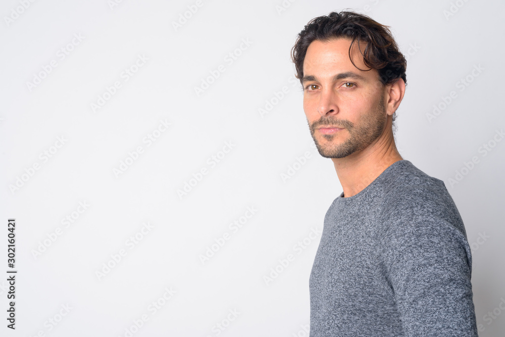 Closeup profile view of handsome Hispanic man looking at camera