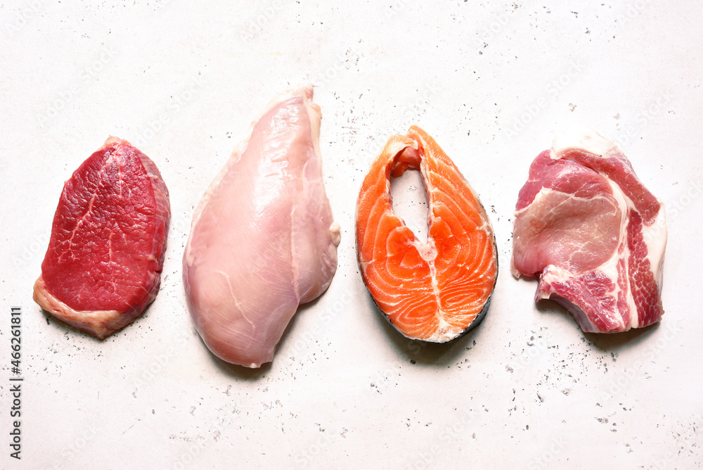 Different types of organic raw meat : beef, chicken, fish and pork. Source of protein. Top view .