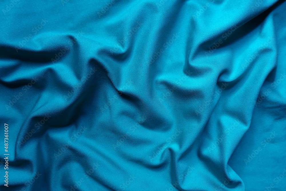 Texture of draped cerulean blue polyester fabric