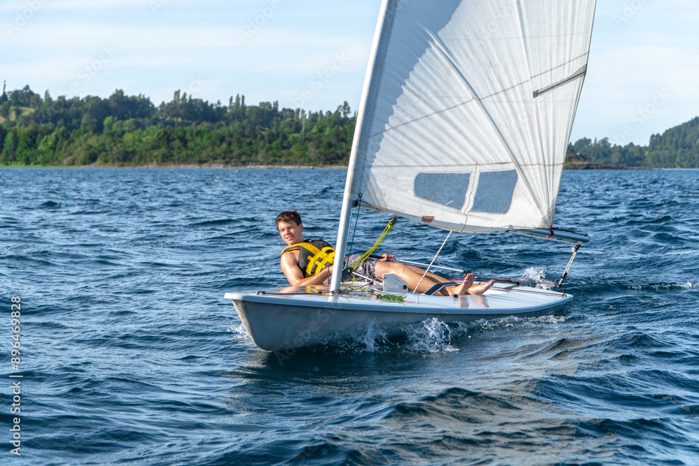 View of a small Laser sailboat sailing on the lake.