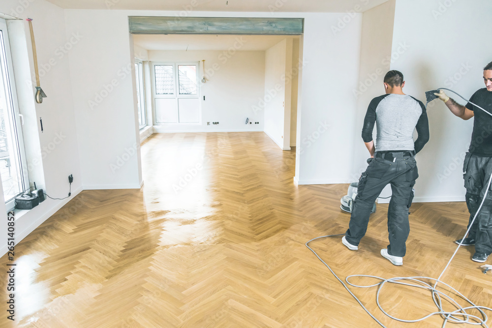 Einölen von Eichenparkett, Arbeiter mit poliermaschine und Werkzeug ...