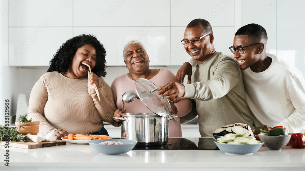 Happy Hispanic family having fun cooking together in modern kitchen - Food and parents unity concept