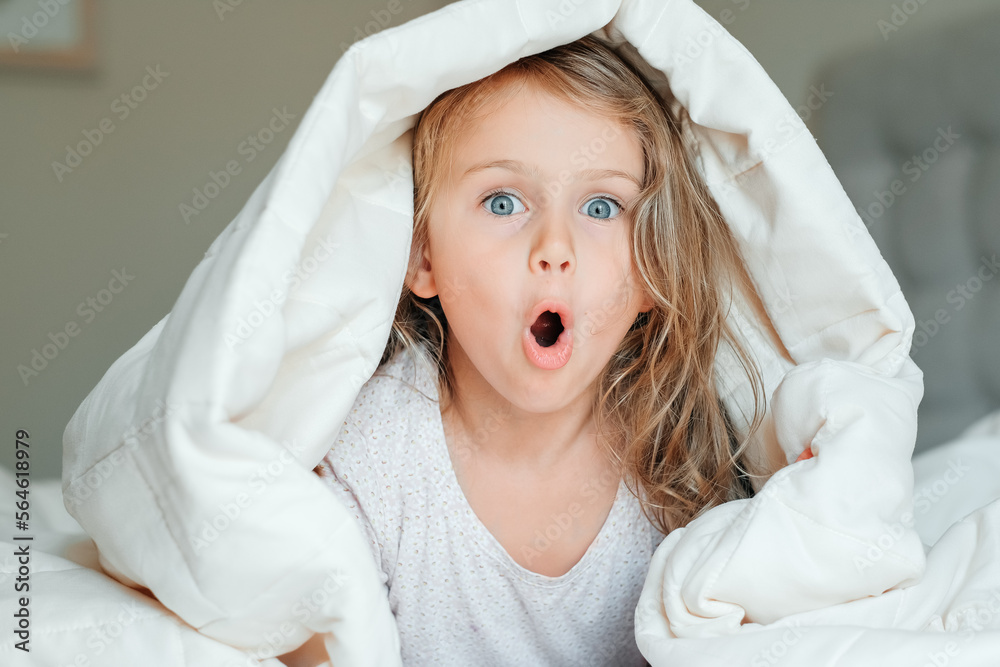 surprised emotion happy excited child adorable girl under white cotton fluffy blanket children emotions