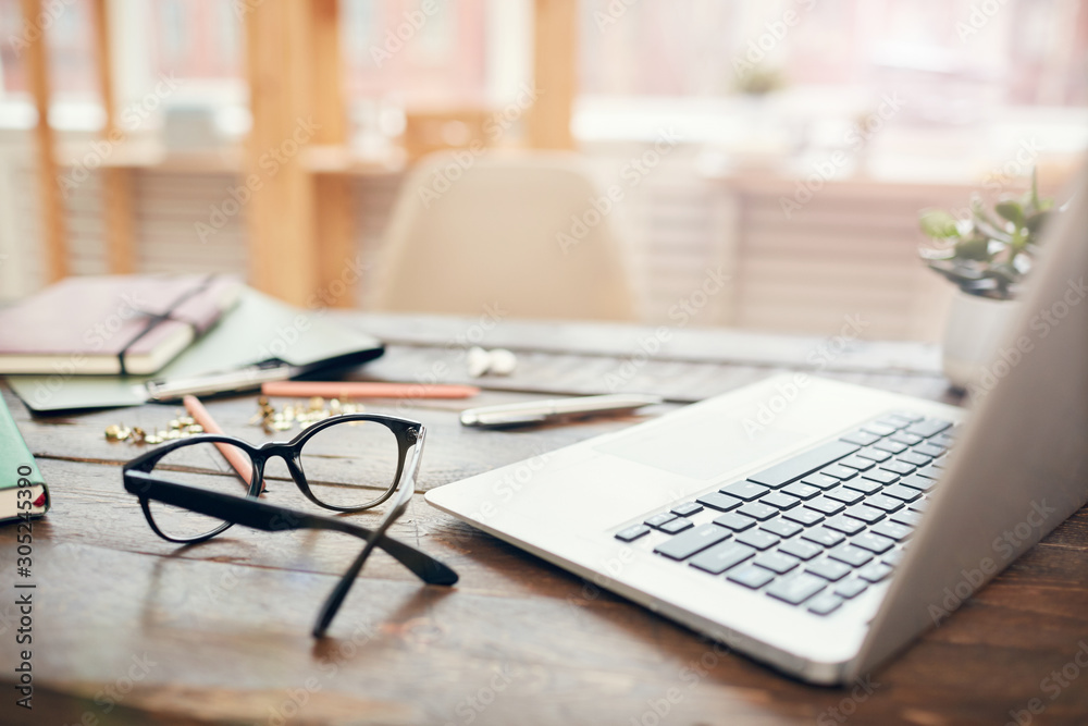 Background image of business office with laptop and supplies on wooden desk,  focus on black hard rim glasses in foreground, copy space Stock Photo |  Adobe Stock