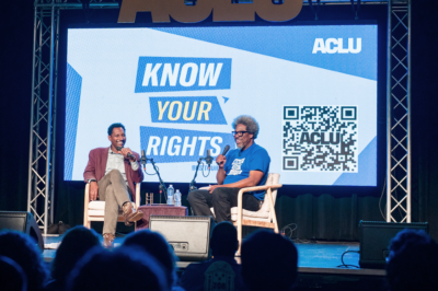 A photo of W. Kamau Bell on stage during the ACLU Know Your Rights Bus Tour.