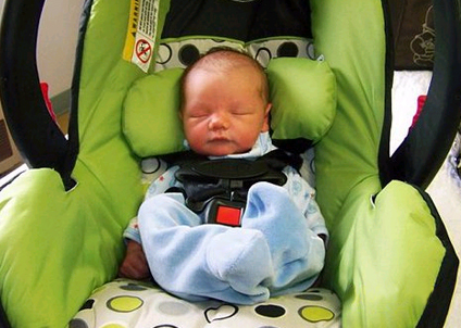 Sleeping newborn in big car seat