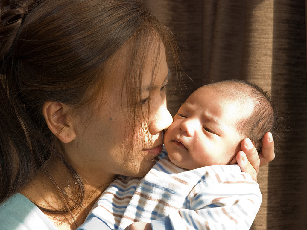 Mum holding her newborn baby close to her face