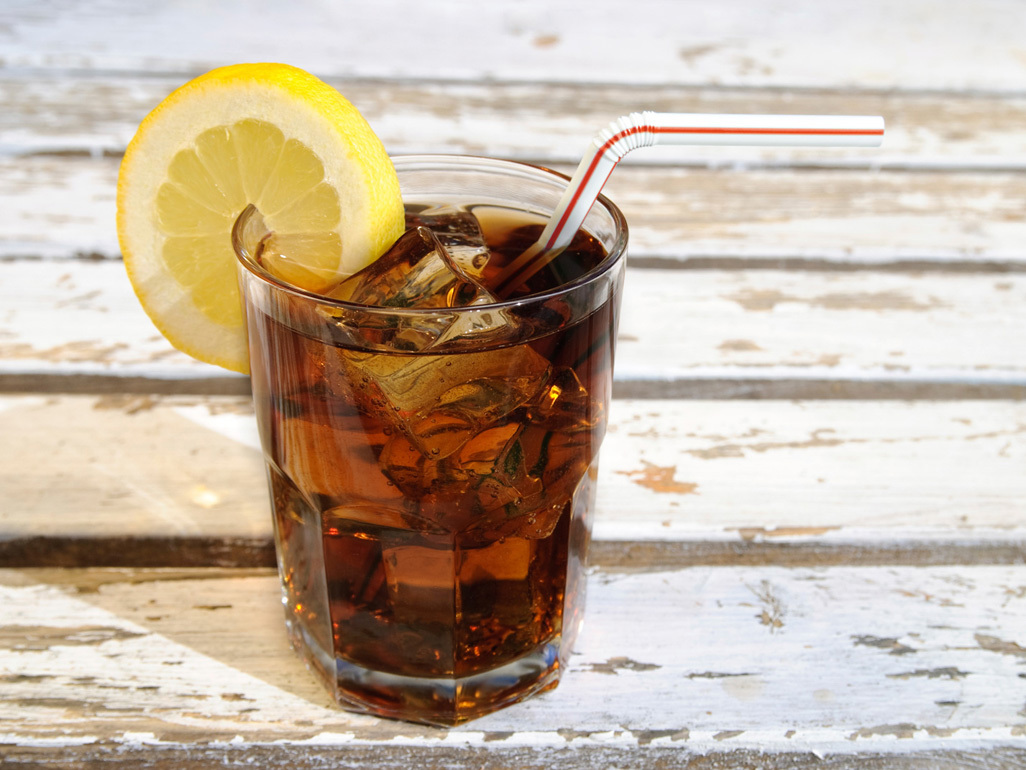 cola drink in a glass with a straw