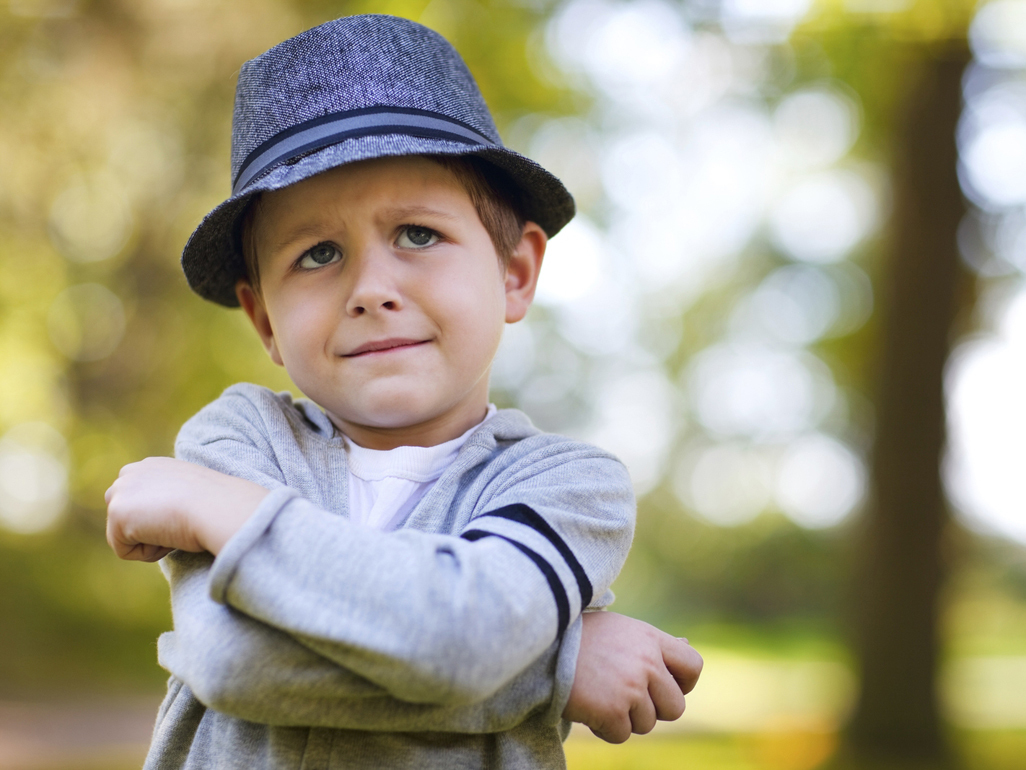 kid wearing a hat making a grimace